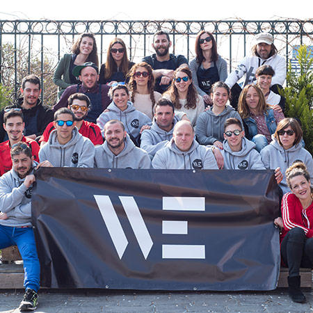 the people of we in group photo holding the logo in the middle